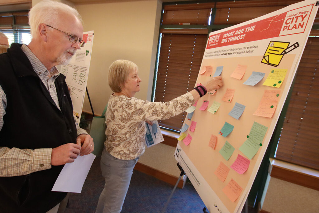 Two senior people looking at a poster at the CZB Wheat Ridge, Colorado Comprehensive Plan meeting