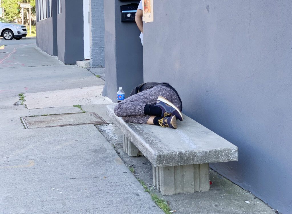 Image of a person sleeping on a concrete bench.